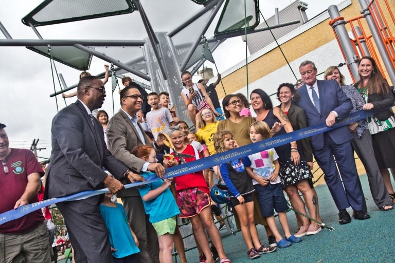 Government officials and Fishtown children cut the ribbon on Fishtown Recreation Center’s new playground. (Kimberly Paynter/WHYY)