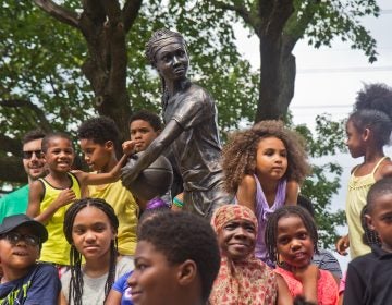 Smith Playground summer camp participants, and Boys and Girls Club members take the first photos in from of the “MVP” Ora Washington statue. (Kimberly Paynter/WHYY)