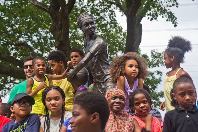 Smith Playground summer camp participants, and Boys and Girls Club members take the first photos in from of the “MVP” Ora Washington statue. (Kimberly Paynter/WHYY)