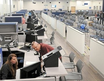 In this Wednesday, Feb. 27, 2019 photo, Acting supervisor Lisa Reeder, left, and supervisor Kevin Keylor of PennDOT Driver's License/Real ID Center run a system test on computers in Bridgeville, Pennsylvania. (Lake Fong/Pittsburgh Post-Gazette via AP)