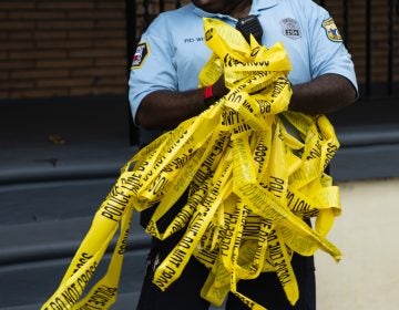 An officer removes crime scene tape after the investigation of what police say was a shooting with one victim in Philadelphia, Wednesday, June 19, 2019. (Matt Rourke/AP Photo)