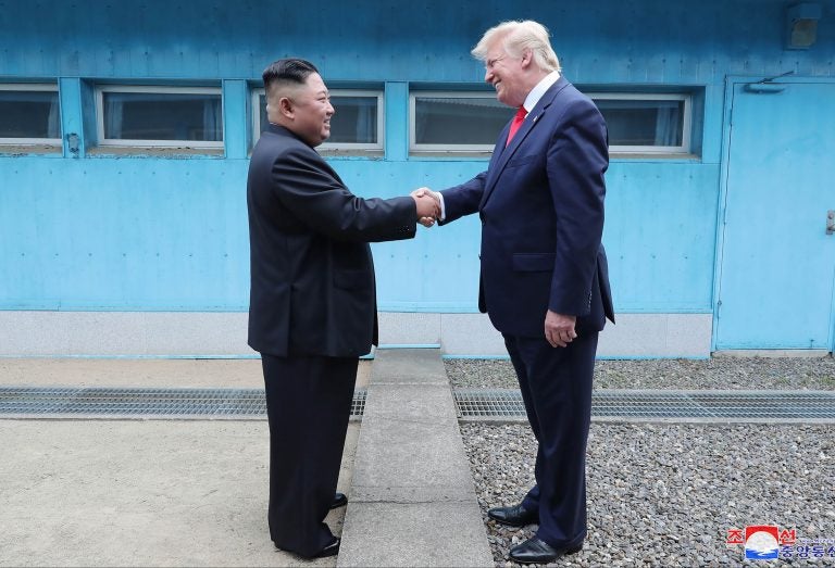 In this Sunday, June 30, 2019, photo provided by the North Korean government, North Korean leader Kim Jong Un, left, and U.S. President Donald Trump shake hands over the military demarcation line at the border village of Panmunjom in Demilitarized Zone. The content of this image is as provided and cannot be independently verified. Korean language watermark on image as provided by source reads: 