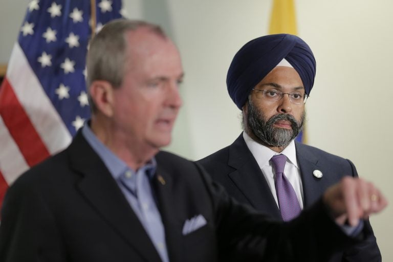 While New Jersey Gov. Phil Murphy, (left), speaks, Attorney General Gurbir Grewal looks on after a bill signing ceremony in Berkeley Heights, N.J., Tuesday, July 16, 2019. Murphy has signed a measure aimed at making so-called smart guns available in the state. He also signed three other measures aimed at reining in gun violence. (Seth Wenig/AP Photo)