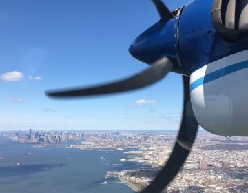 In this 2018 photo, a Twin Otter aircraft flies over New York Harbor and New York City on a research mission. In older Eastern US cities, nine times as much natural gas is leaking out of pipelines, homes than federal government had thought. (Eric Kort/University of Michigan via AP)