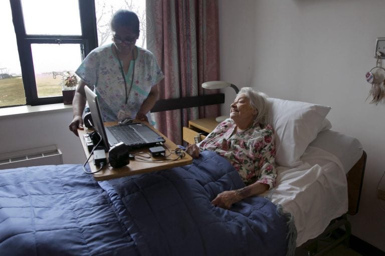 A nurse's aide helps nursing home patient Louise Irving on Wednesday, March 25, 2015. (Richard Drew/AP Photo)