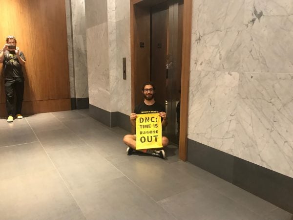 A protester block an elevator in the building. (Naomi Brauner/WHYY)