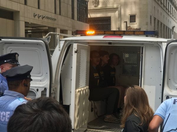 Some of the arrested protesters singing from inside of the police van. (Naomi Brauner/WHYY)