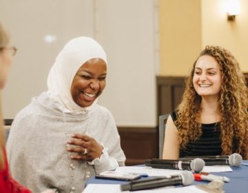 Conversationalists Kameelah Mu'Min Rashad and Emily Zislis share a laugh with WHYY’s Jennifer Lynn during A Conversation on Identity and Belonging hosted at the University of Pennsylvania. (Riley Jackson/Interfaith Philadelphia)