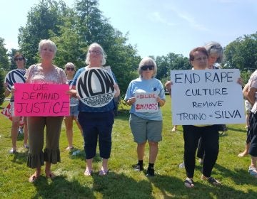 From left, Carol Gay, Joni Brennan Catherine Hunt and JJ Mistretta hold signs at a protest in Freehold to demand the removal of Judges Troiano and Silva on July 11, 2019. (Nicholas Pugliese/WHYY)