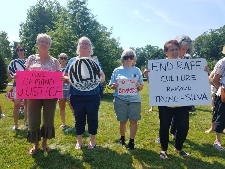 From left, Carol Gay, Joni Brennan Catherine Hunt and JJ Mistretta hold signs at a protest in Freehold to demand the removal of Judges Troiano and Silva on July 11, 2019. (Nicholas Pugliese/WHYY)