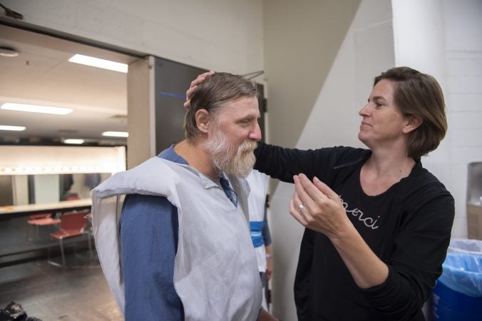 Wearing a baseball cap on his way to the rehearsal, Nelson Hawthorne arrives with hat hair which director Kittson O’Neill matted down. (Jonathan Wilson for WHYY)