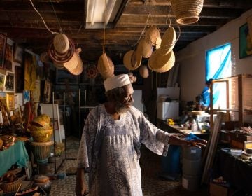 Sharif Abdur-Rahim, one of two founding brothers of West Philadelphia's African Cultural Arts Forum, stands in a second-floor workshop used to store African art and to produce the oils, incense and personal-care products they sell. (Kriston Jae Bethel for NextCity)