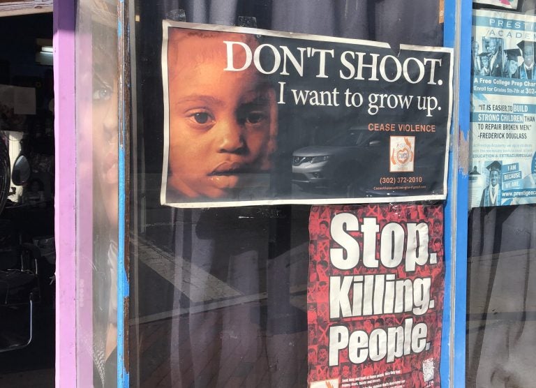 posters on a barbershop window in downtown Wilmington