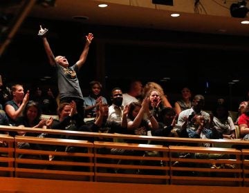 KHSA English teacher Maddie Luebbert throws their hands up in celebration and cheers with other faculty, staff, and City Year leaders, as they learn that the Tiger Poets will advance to the second round at championships. (Photo by Maggie Loesch)