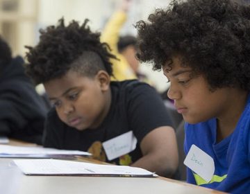 Fifth-graders Thomas Medley, (left), and Devin Walker study their training materials as they learn to become student leaders at Woodland Hills Intermediate in 2017. (The University of Pittsburgh)