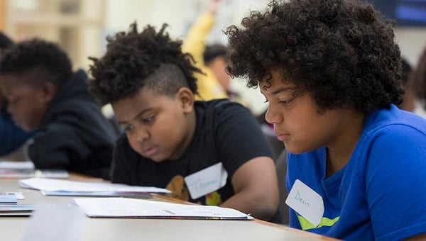 Fifth-graders Thomas Medley, (left), and Devin Walker study their training materials as they learn to become student leaders at Woodland Hills Intermediate in 2017. (The University of Pittsburgh)