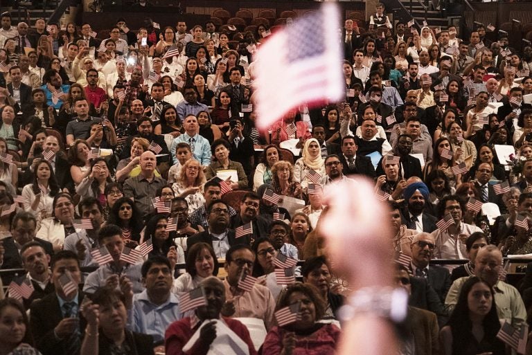 A naturalization ceremony of new U.S. citizens at the Hylton Performing Arts Center in Manassas, Virginia. The U.S. citizenship oath today is 140 words. It wasn't until 1929 that the oath's text was standardized, and the oath was amended in 1952 to emphasize service to country as the U.S. faced a growing threat from the Soviet Union. (Shuran Huang/NPR)