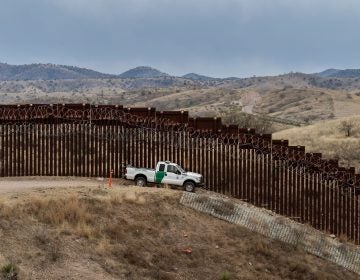 A Border Patrol officer guards the U.S.-Mexico border fence in Nogales, Ariz., in February. The Supreme Court on Friday said the Trump administration could continue with its plan to use military funds to build a wall along sections of the southern border. (Ariana Drehsler/AFP/Getty Images)