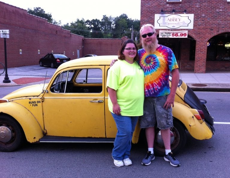 Jessica Bray and her husband, Anthony Bray, pose with their 1970 Volkswagen Beetle. Anthony converted his Beetle to an electric car. 