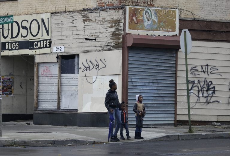 In this Thursday, Nov. 3, 2016, photo, pedestrians in Newburgh, an upstate New York city already struggling with poverty and violent crime were told to have their blood tested for a toxic chemical because its water supply was found to have high levels of the cancer-linked chemical PFOS that was used for firefighting at the nearby military base. (AP Photo/Mike Groll)