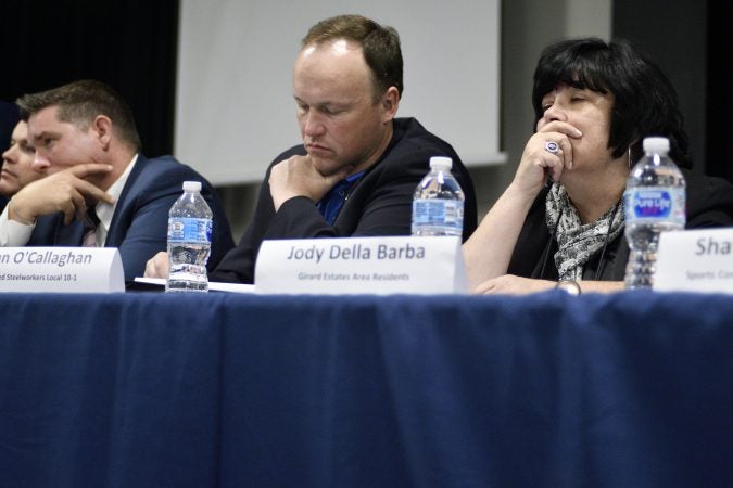 Members of refinery advisory group, Rich Lazer, Ryan O'Callaghan and Jody Della Barba listen to statements and comments from local residents and activists during the first of a series of community meetings, at Preparatory Charter School, on Tuesday. (Bastiaan Slabbers for WHYY)