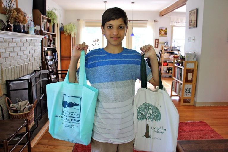 Kiran Schatz, 12, carries his school supplies home in reusable bags. The West Chester student and his classmates worked to promote legislation that would ban the use of disposable plastic bags in their town. (Emma Lee/WHYY)