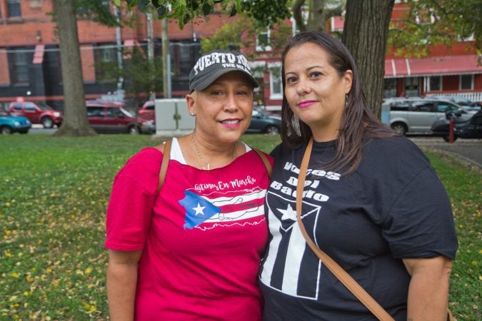 Organizers Kimberly Lamberti of Latinos En Marcha and Ana Montañez, with Voces del Barrio, celebrate the resignation of Puerto Rican governor Ricardo Rosselló at Fairhill Square in Kensington. (Kimberly Paynter/WHYY)