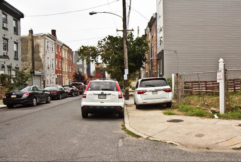 Cars park on the sidewalk on Coral Street