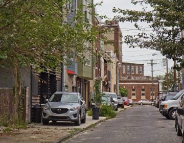 Cars are parked on the sidewalk on Fletcher Street in Philadelphia’s East Kensington neighborhood. (Kimberly Paynter/WHYY)