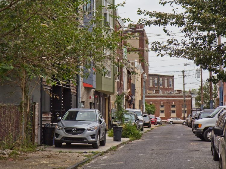 Cars are parked on the sidewalk on Fletcher Street in Philadelphia’s East Kensington neighborhood.