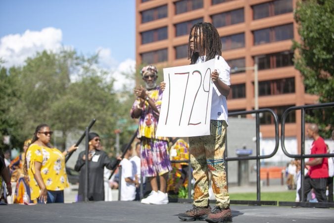 Qahhaaru Re-Imhotep, 10, wals on stage representing the year 1729 during an event to commemorate the 400th anniversary of the first arrival of enslaved Africans at the President's House. (Miguel Martinez for WHYY)