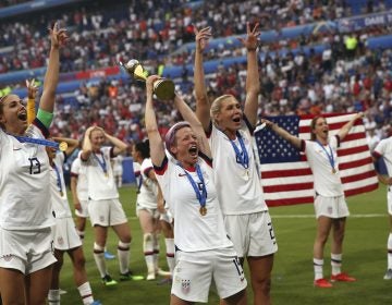United States' Megan Rapinoe, center, holds the trophy as she celebrates with teammates after they defeated the Netherlands 2-0 in the Women's World Cup final soccer match at the Stade de Lyon in Decines, outside Lyon, France, Sunday, July 7, 2019. (AP Photo/Francisco Seco)