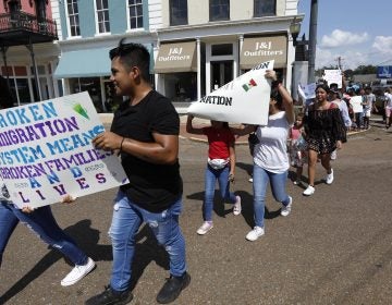 In this Aug. 11, 2019 photo, children of mainly Latino immigrant parents hold signs in support of them and those individuals picked up during an immigration raid at a food processing plant in Canton, Miss., following a Spanish Mass at Sacred Heart Catholic Church in Canton, Miss. Trump administration rules that could deny green cards to immigrants if they use Medicaid, food stamps, housing vouchers or other forms of public assistance are going into effect. (Rogelio V. Solis./AP Photo)