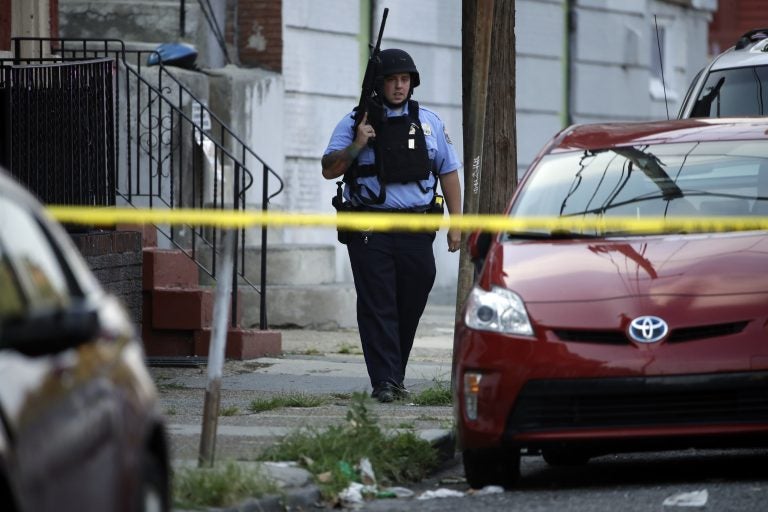 A police officer patrols the block near a house as they investigate an active shooting situation, Wednesday, Aug. 14, 2019, in the Nicetown neighborhood of Philadelphia. (AP Photo/Matt Rourke)