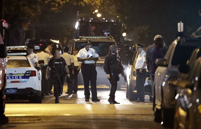 Police remain on the scene after a gunman was apprehended following a standoff Thursday, Aug. 15, 2019, in Philadelphia. A gunman who opened fire on police Wednesday as they were serving a drug warrant in Philadelphia, wounding several officers and triggering a standoff that extended into the night, is in police custody, authorities said. (AP Photo/Matt Rourke)