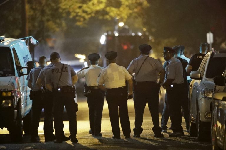 Policer officers watch as a gunman is apprehended following a standoff Wednesday, Aug. 14, 2019, in Philadelphia. (AP Photo/Matt Rourke)