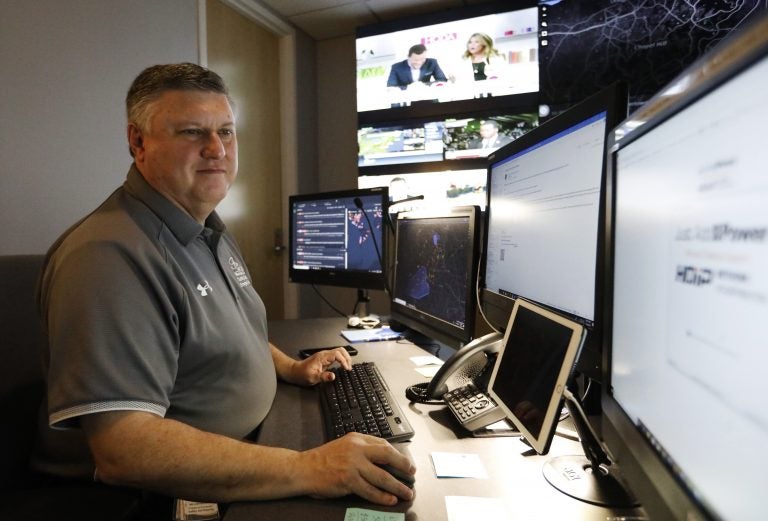 In this July 30, 2019, photo, Paul Hildreth, emergency operations coordinator for the Fulton County School District, works in the emergency operations center at the Fulton County School District Administration Center in Atlanta. Artificial Intelligence is transforming surveillance cameras from passive sentries into active observers that can immediately spot a gunman, alert retailers when someone is shoplifting and help police quickly find suspects. (Cody Jackson/AP Photo)