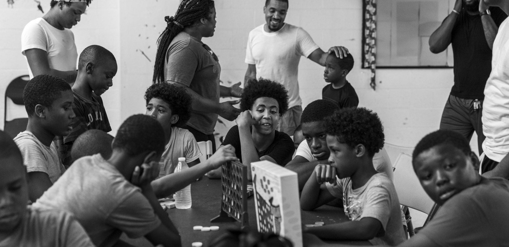 Rahdeem Abdullah (top center) connects with a student in the basement game room at Gathers. Shawn (center) watches younger kids in his role as a counselor in Aunt Cheryl's day camp. (Jessica Kourkounis for Keystone Crossroads)