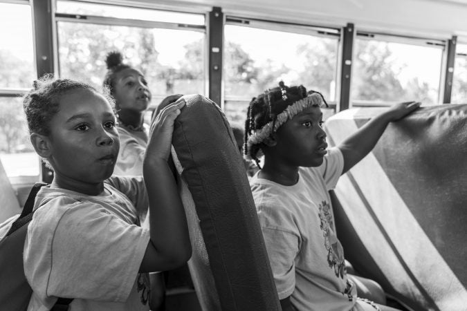 A yellow school bus takes kids from day camp on a trip to Fairmount Park. (Jessica Kourkounis for Keystone Crossroads)
