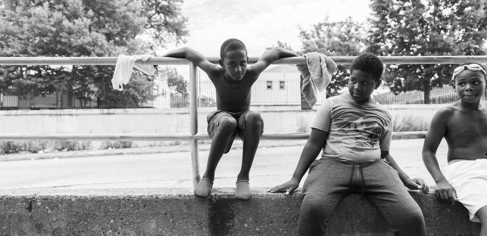 Kids hang out on the 25th Street side of the Hank Gathers Rec Center. Raymond Rosen Manor, a public housing complex, sits behind them. (Jessica Kourkounis for Keystone Crossroads)