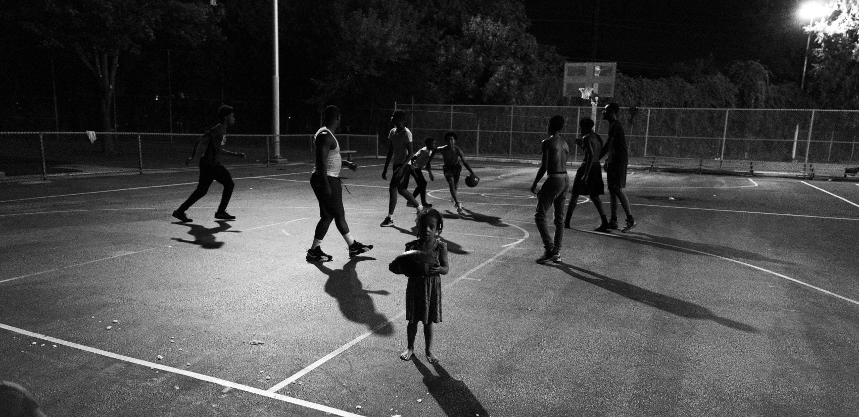 A young girl wanders onto the court during a night game at Gathers. (Jessica Kourkounis for Keystone Crossroads)