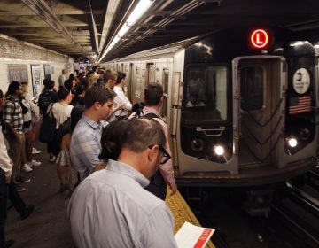 Straphangers wait for an L Train in New York City as it pulls into the First Avenue station. A bill under consideration might bar New York from replacing these cars with Chinese-made ones. (Mark Lennihan/AP)