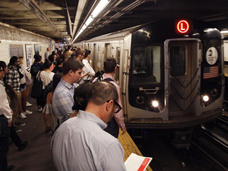 Straphangers wait for an L Train in New York City as it pulls into the First Avenue station. A bill under consideration might bar New York from replacing these cars with Chinese-made ones. (Mark Lennihan/AP)