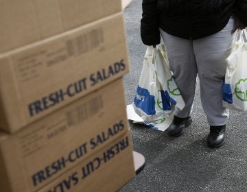 An FDA contract worker collects food and supplies from a food pantry in Baltimore. In the face of a Trump administration proposal that could cause 3 million people to lose federal food assistance, mayors from 70 cities are pushing back. (Patrick Semansky/AP Photo)