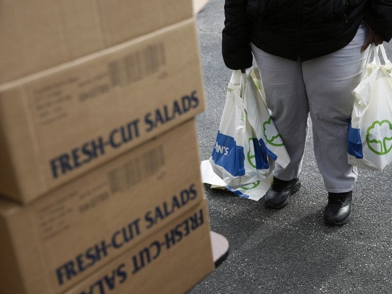 An FDA contract worker collects food and supplies from a food pantry in Baltimore. In the face of a Trump administration proposal that could cause 3 million people to lose federal food assistance, mayors from 70 cities are pushing back. (Patrick Semansky/AP Photo)