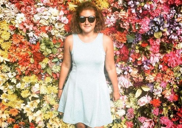 Emily Fredricks pictured in front of a flower wall. (Emily Fredricks Foundation)