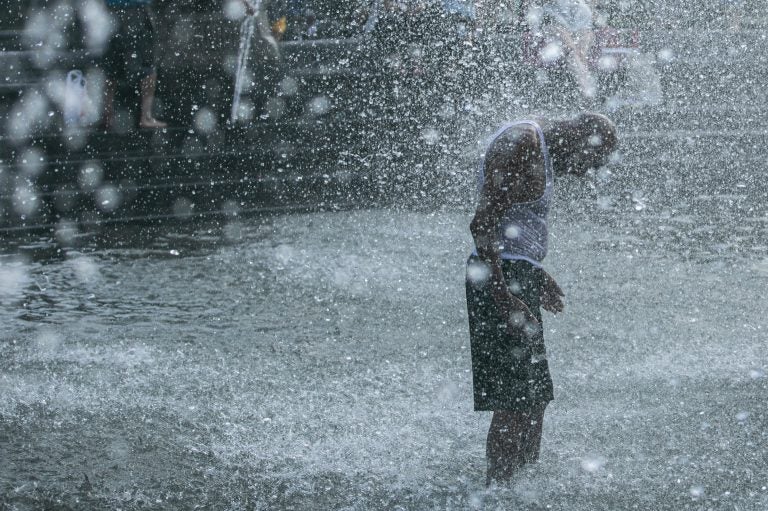 A man cools off in a fountain in New York's Washington Square Park this summer. Death from all causes doubled during a heat wave in New York City in August 1975, with heart attacks and strokes accounting for a majority of the excess deaths. (Jeenah Moon/Bloomberg via Getty Images)
