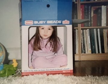 Liz Tung, at 3 years old, pretends to be on television using a cardboard box. (Image courtesy of Liz Tung)