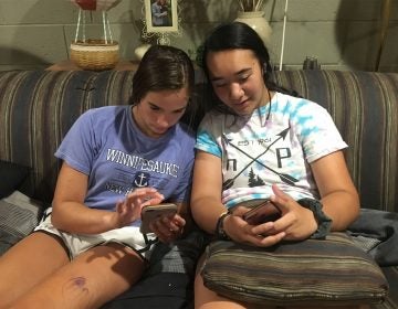 Kim Delea (left) and Alyssa Carroll, eyes on their smartphones.
(Randy Scott Carroll for WHYY)
