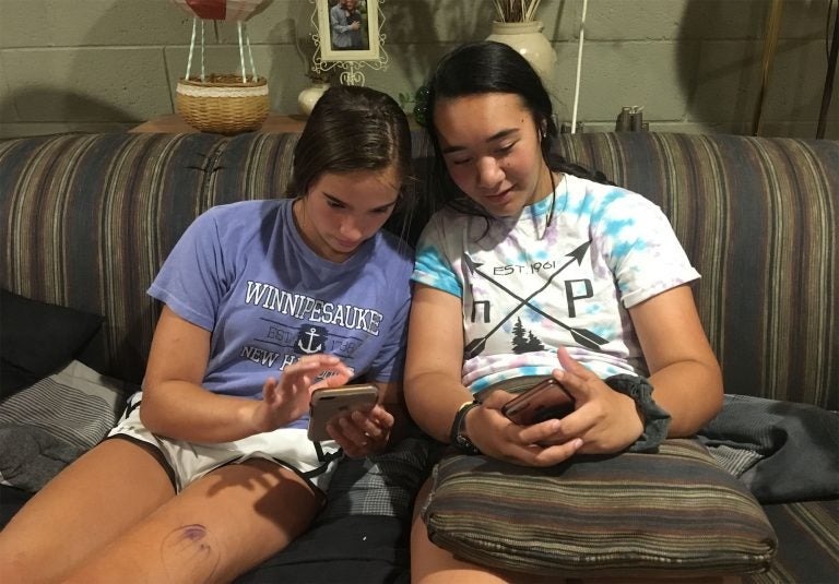 Kim Delea (left) and Alyssa Carroll, eyes on their smartphones.
(Randy Scott Carroll for WHYY)
